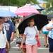 Ann Arbor Art Fair goers stay dry under their umbrellas as they wander down Main St and The Summer Art Fair on Wednesday. Melanie Maxwell I AnnArbor.com